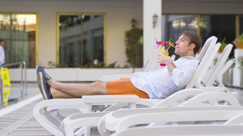 cocktail-by-the-pool-at-the-hotel-man-lying-on-sun-lounger-by-the-pool-drinking-cocktail-video.jpg